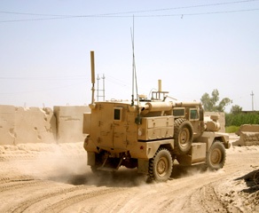 Military-Tank-Driving-Down-Dusty-Road-in-Desert